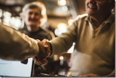 Close up of senior man shaking hands with insurance broker