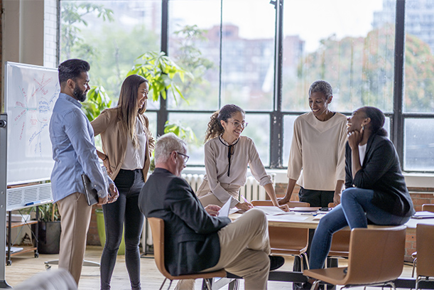 Different ethnicity and age businesspeople gathered together at boardroom for negotiations and planning future collaboration lead by african smiling businesswoman or corporate training process concept