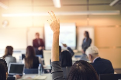 employee raising their hand during a company benefit review