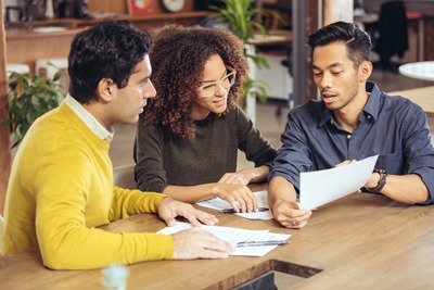 couple discussing with their financial advisor to see if they can afford health insurance benefits