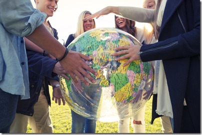 Group of young people holding a world globe