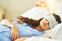 Cropped shot of an attractive young woman wearing a sleep mask while lying in bed